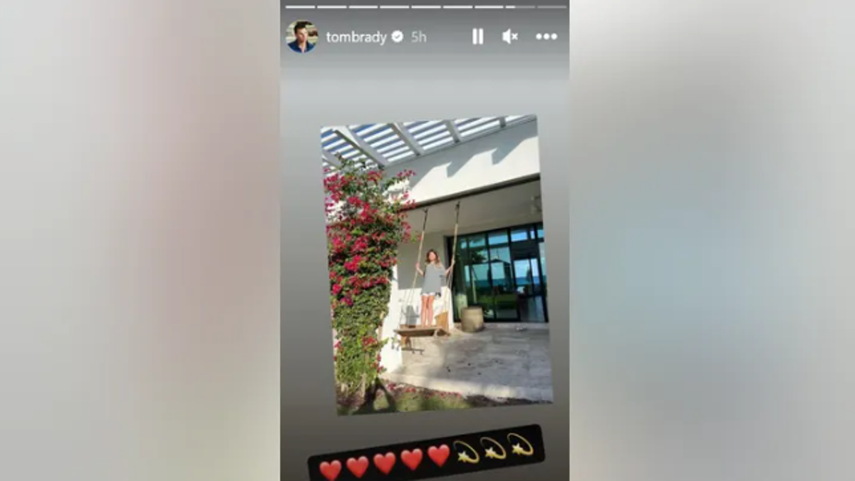 Tom Brady's daughter Vivian standing on a swing outdoors