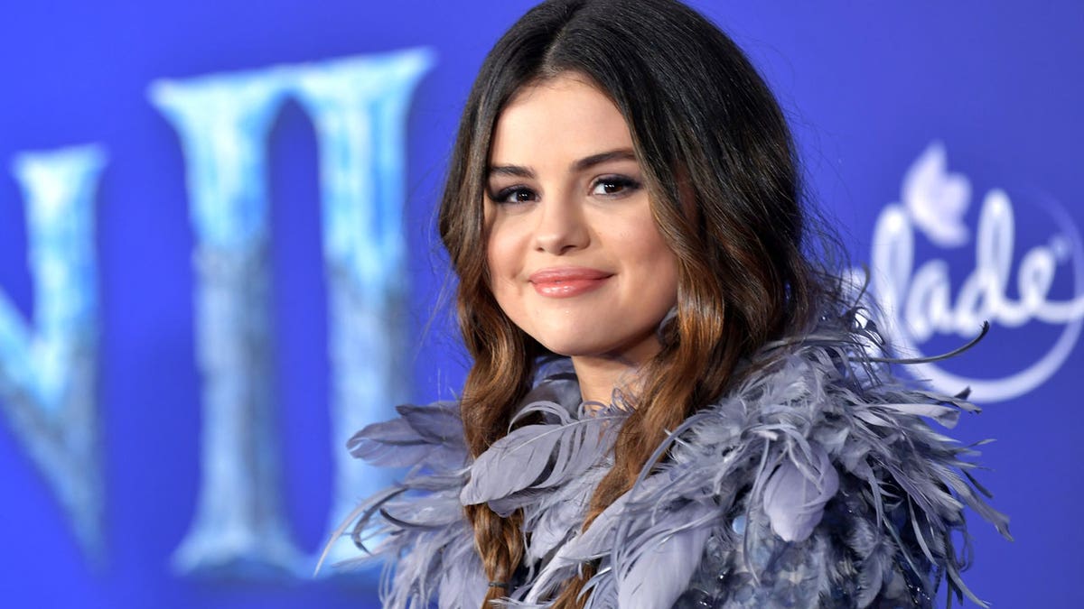 Selena Gomez smiles at the camera during an event.