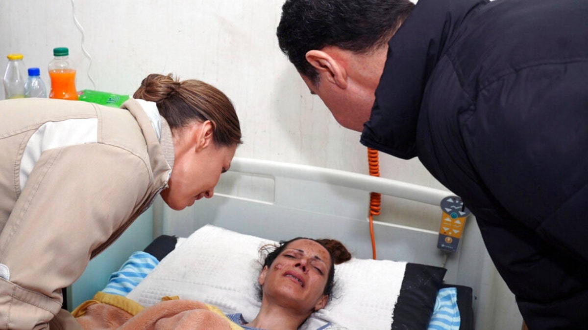 Syrian President Bashar Assad and his wife visit a wounded survivor of a devastating earthquake
