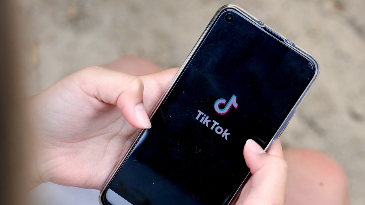 Una chica sostiene un teléfono con TikTok abierto