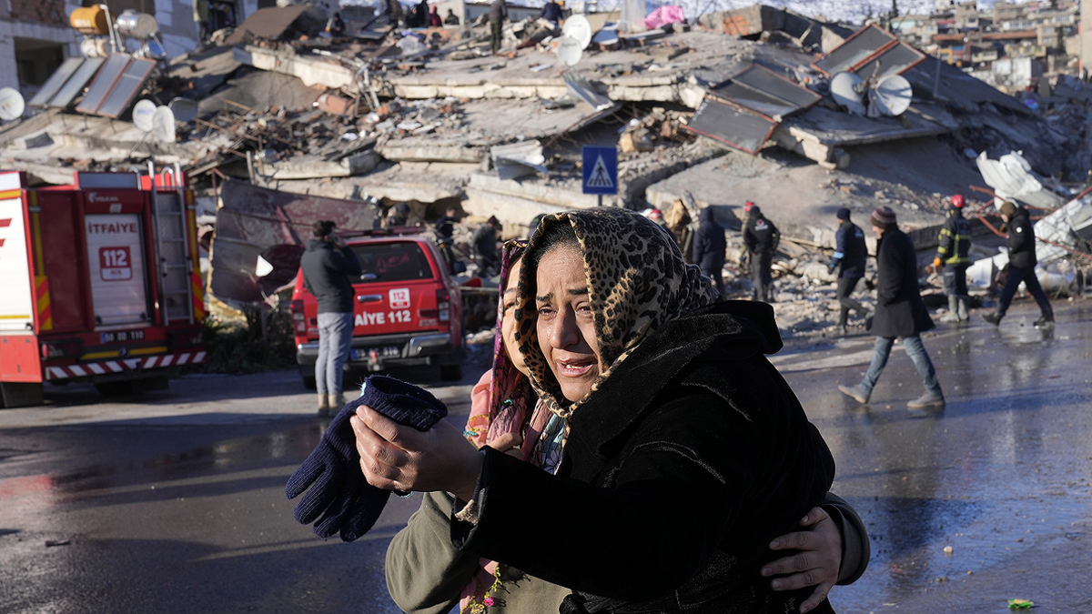 Turkish women cry in front of destroyed building after earthquake