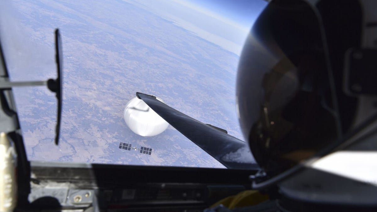 Chinese spy balloon in background seen from cockpit of US fighter jet