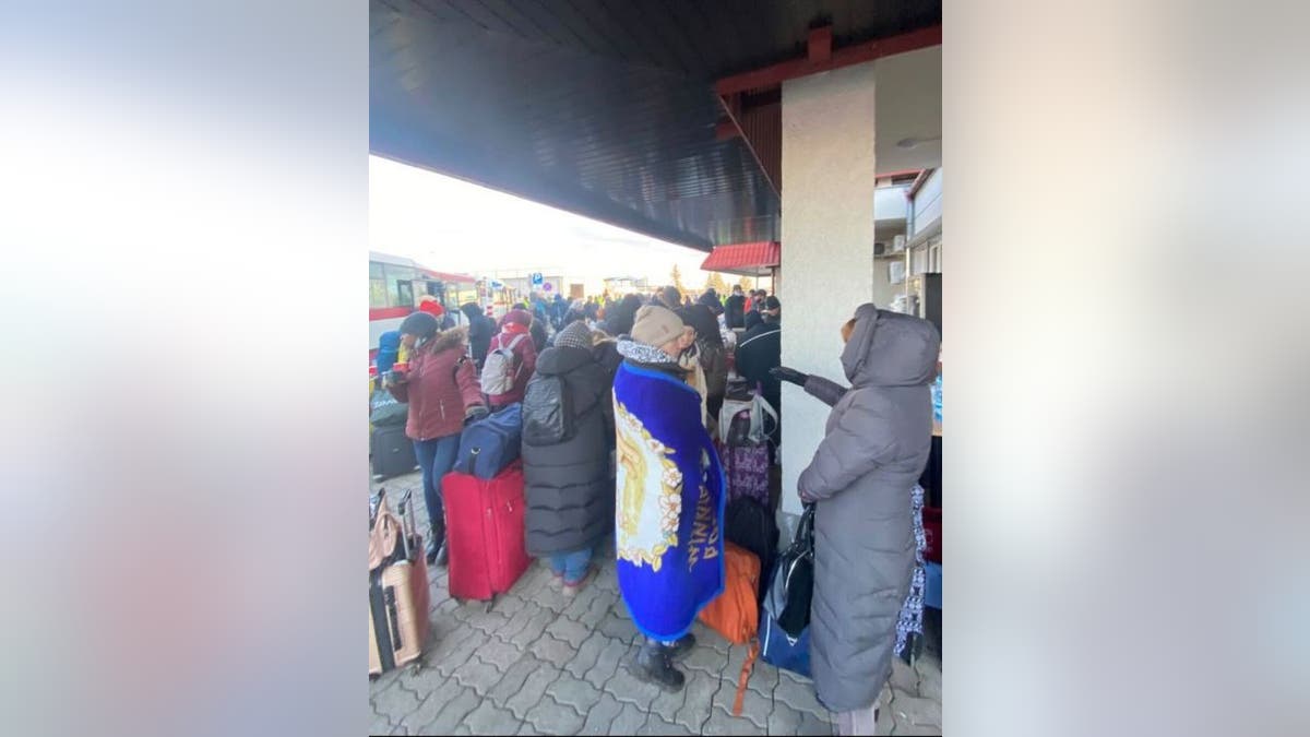 Ukrainians trying to stay warm while waiting to cross the border