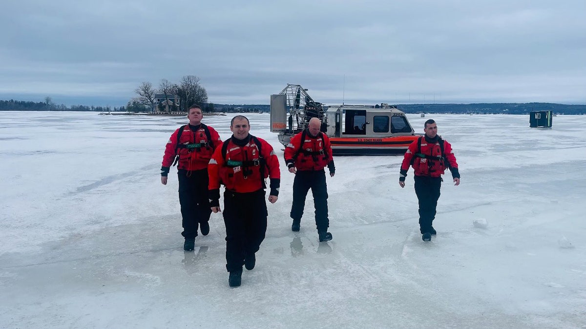 USCG crew on ice with boats