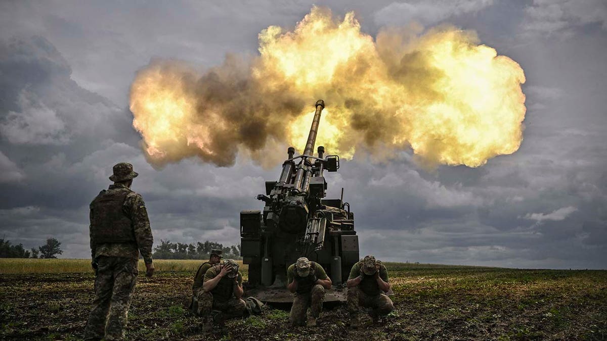 A group of soldiers fire a weapon.