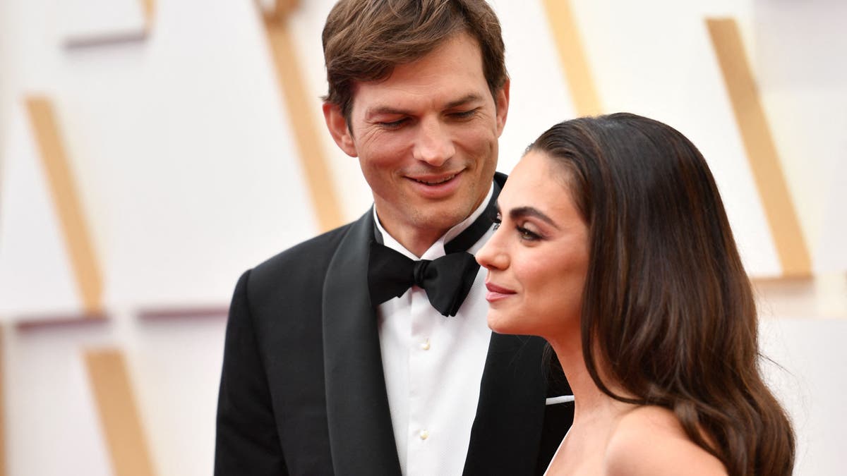 Ashton Kutcher and Mila Kunis pose together on the red carpet