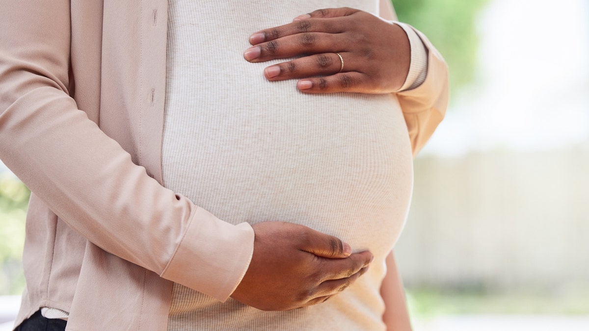 Pregnant woman holding belly