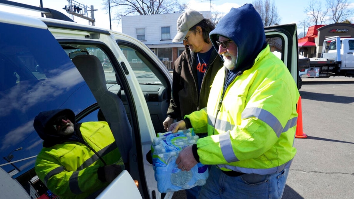 A volunteer helps load water into a car in East Palestine