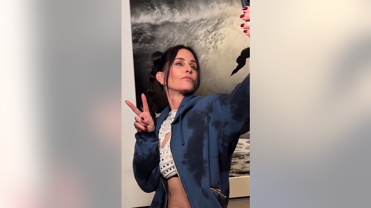 Courteney Cox flashes a peace sign for a selfie.