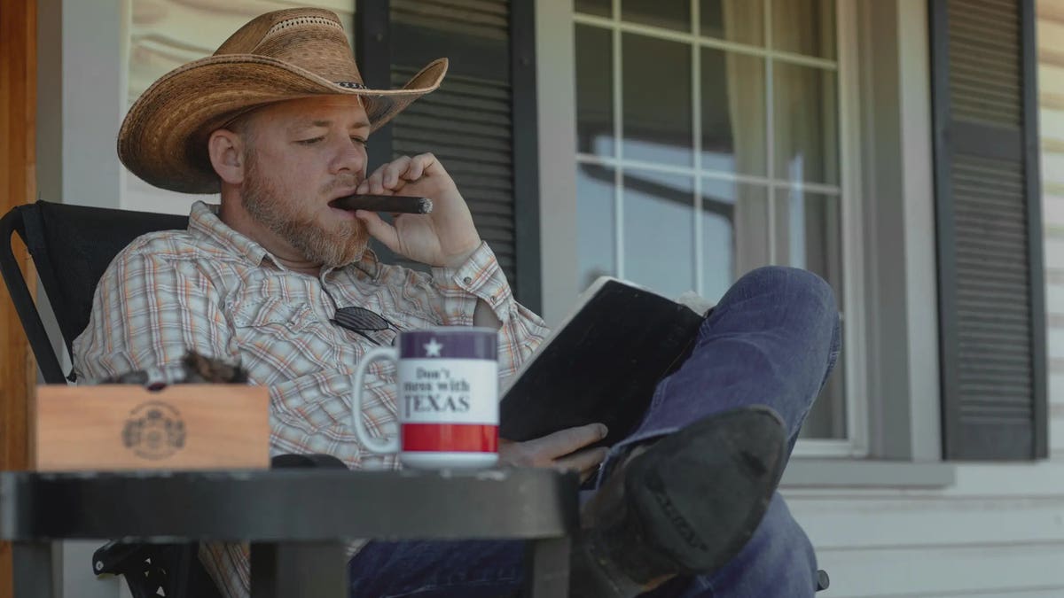 Gabriel Rench smokes cigar on front porch