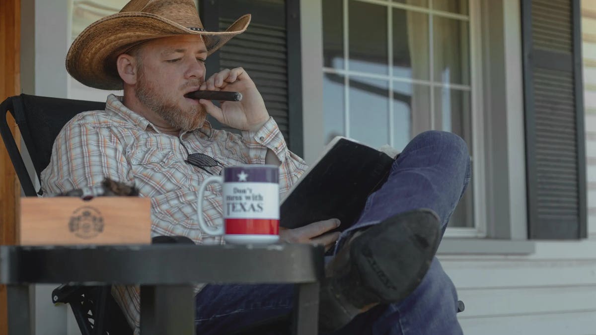 Gabriel Rench smoking cigar on porch