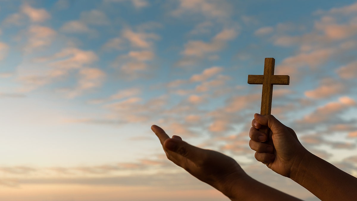 hands holding cross in worship