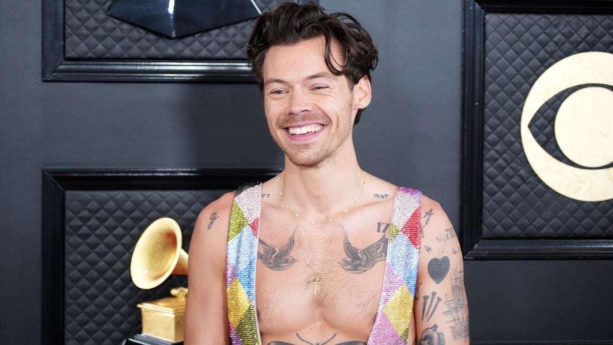 Harry Styles smiles on the 2023 Grammys red carpet.