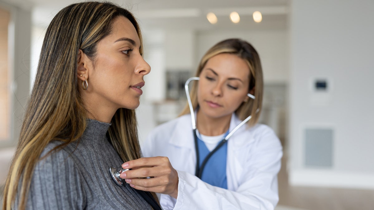 doctor checks patient's heart