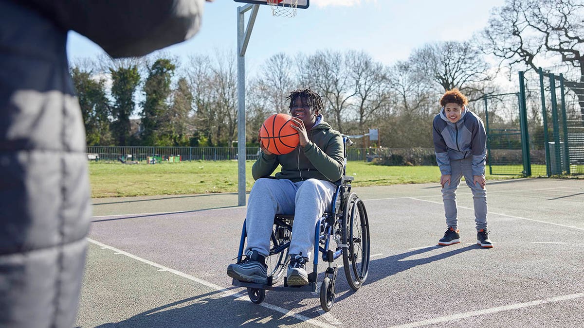 boy in wheelchair shoots hoops