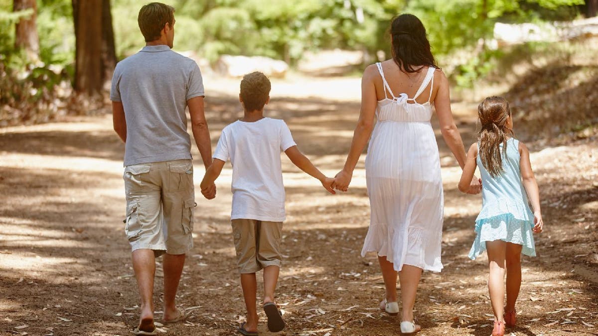 Family walking down forested path