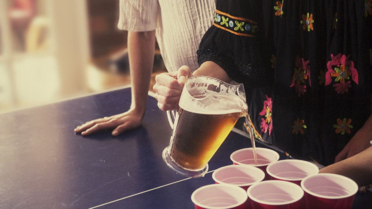 Person pours beer in cups