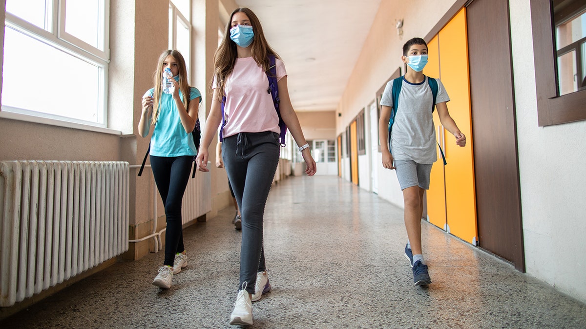 students walking in school with masks