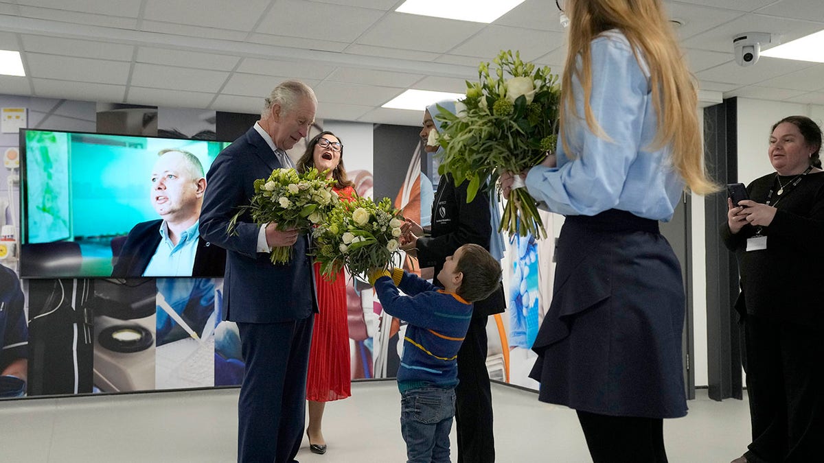 King Charles receives flowers from a little boy