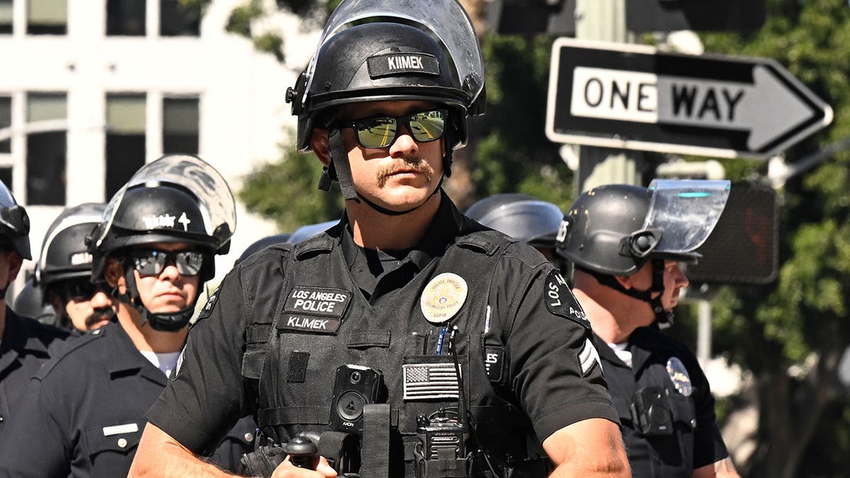 LAPD officer holds gun while outside