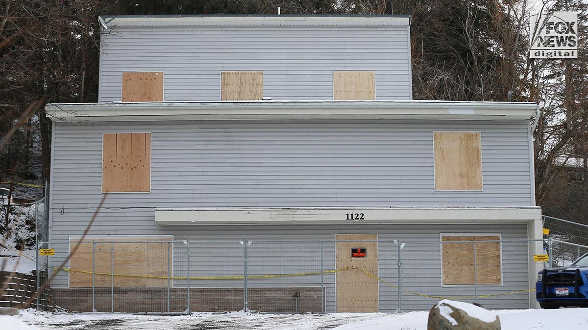 Front of the house with plywood boards on all the windows and doors