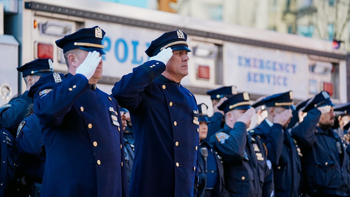 police officers saluting outside mosque for funeral