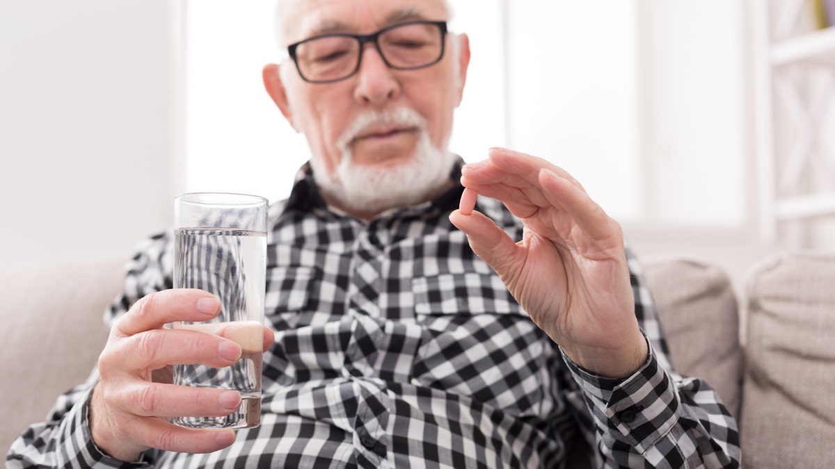 Old man taking medicine