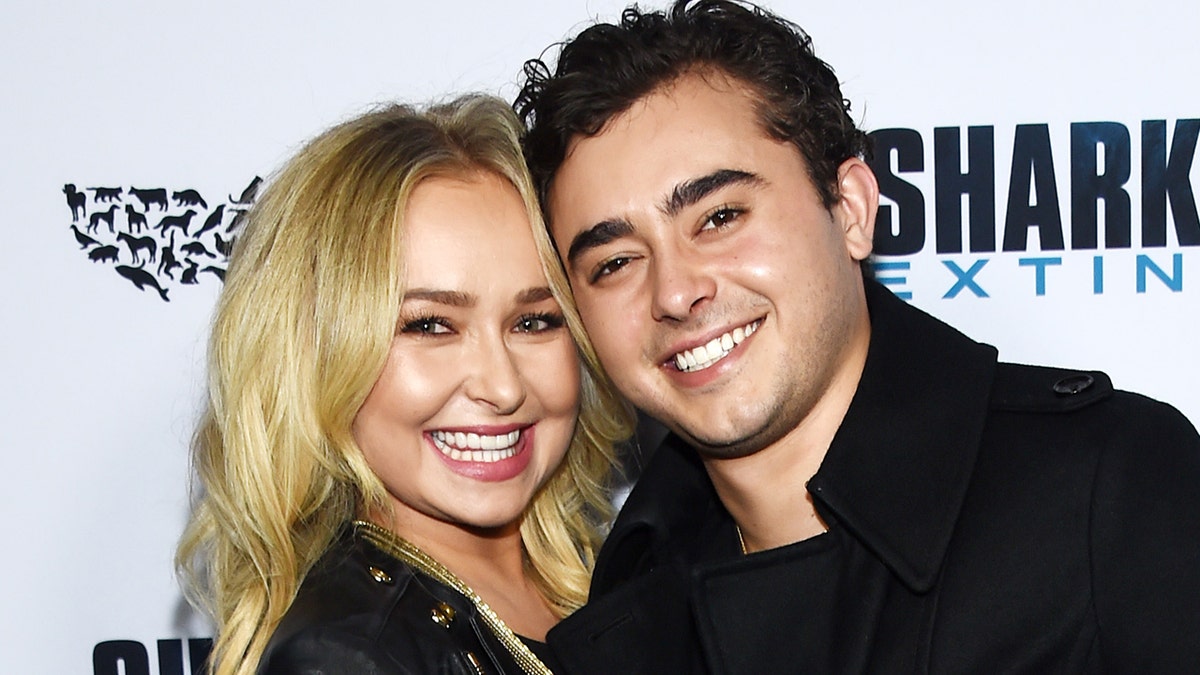 Hayden Panettiere smiles in a black jacket with her brother Jansen, also in black, on the carpet in Hollywood