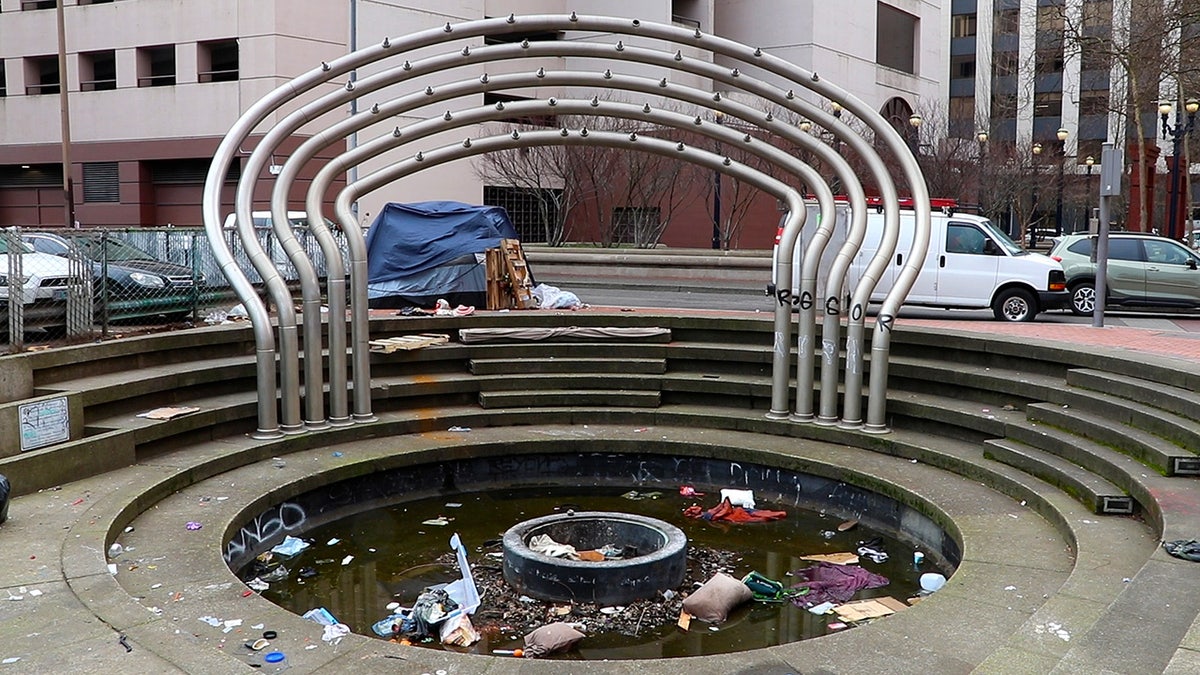 trash fills fountain in Portland, homeless tent on sidewalk