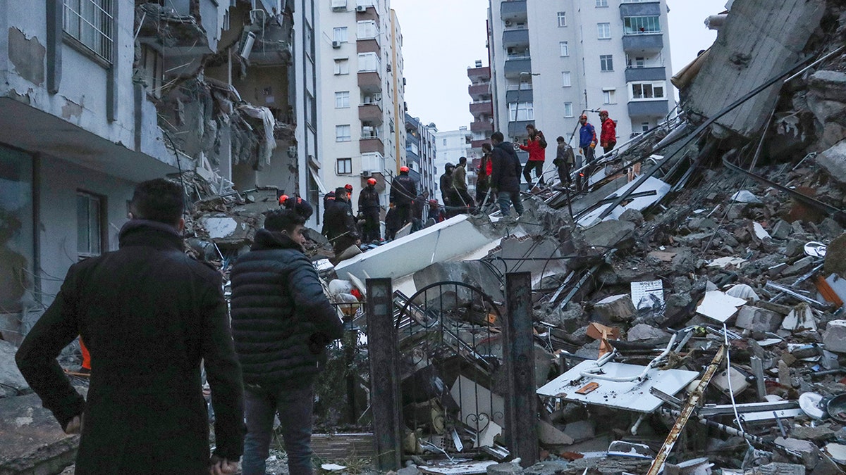 people searching rubble