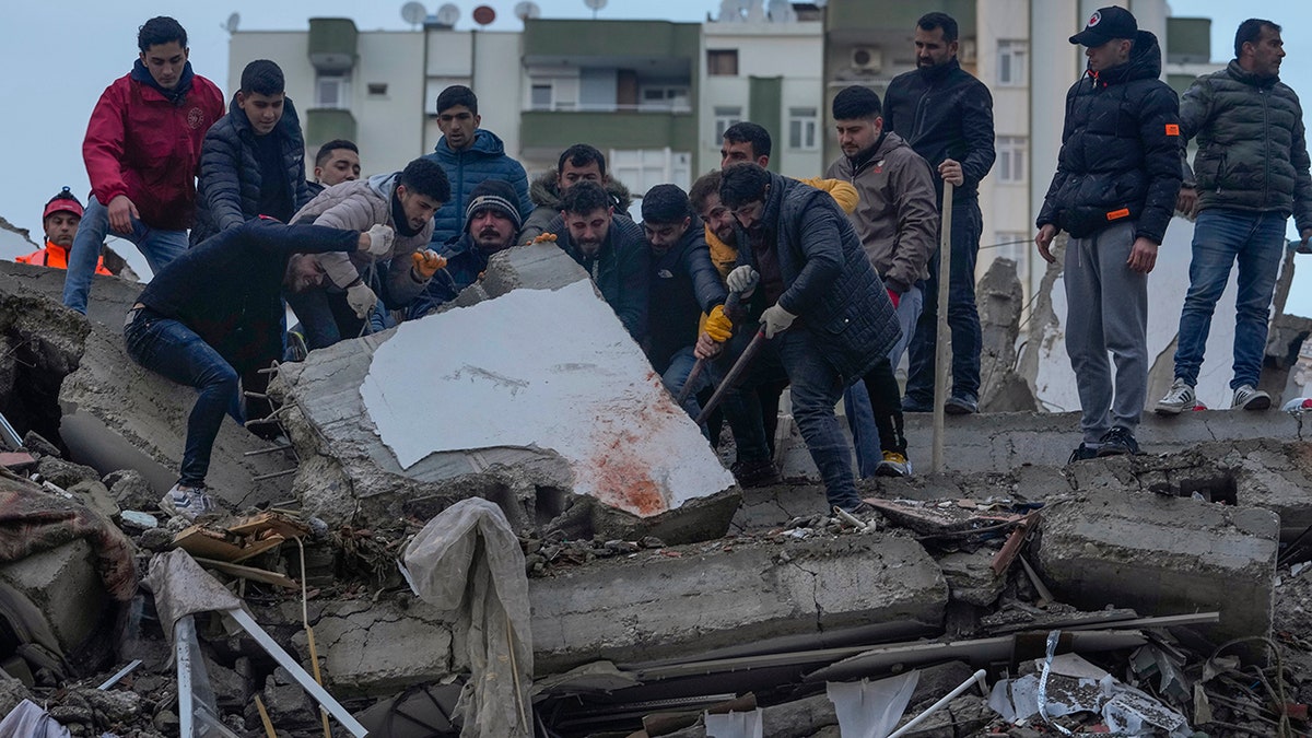 men searching pile of debris