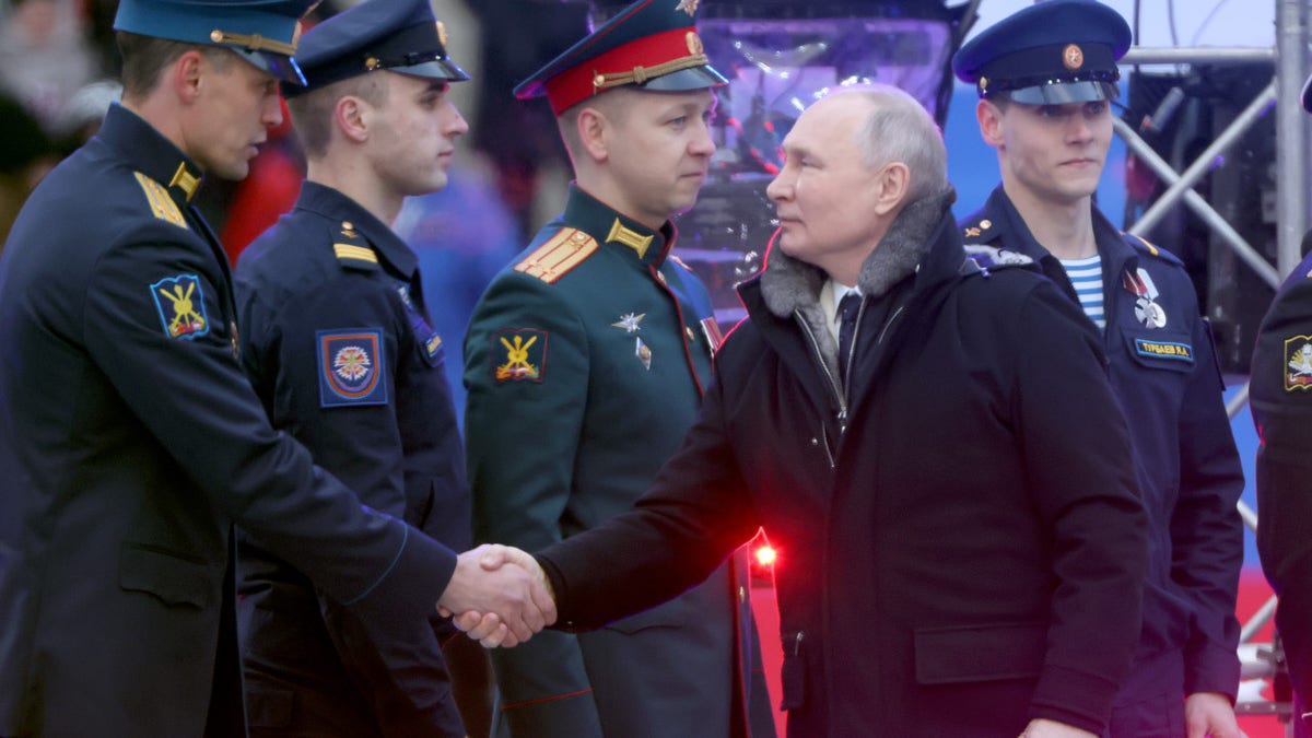 Russian President Vladimir Putin greets members of the military