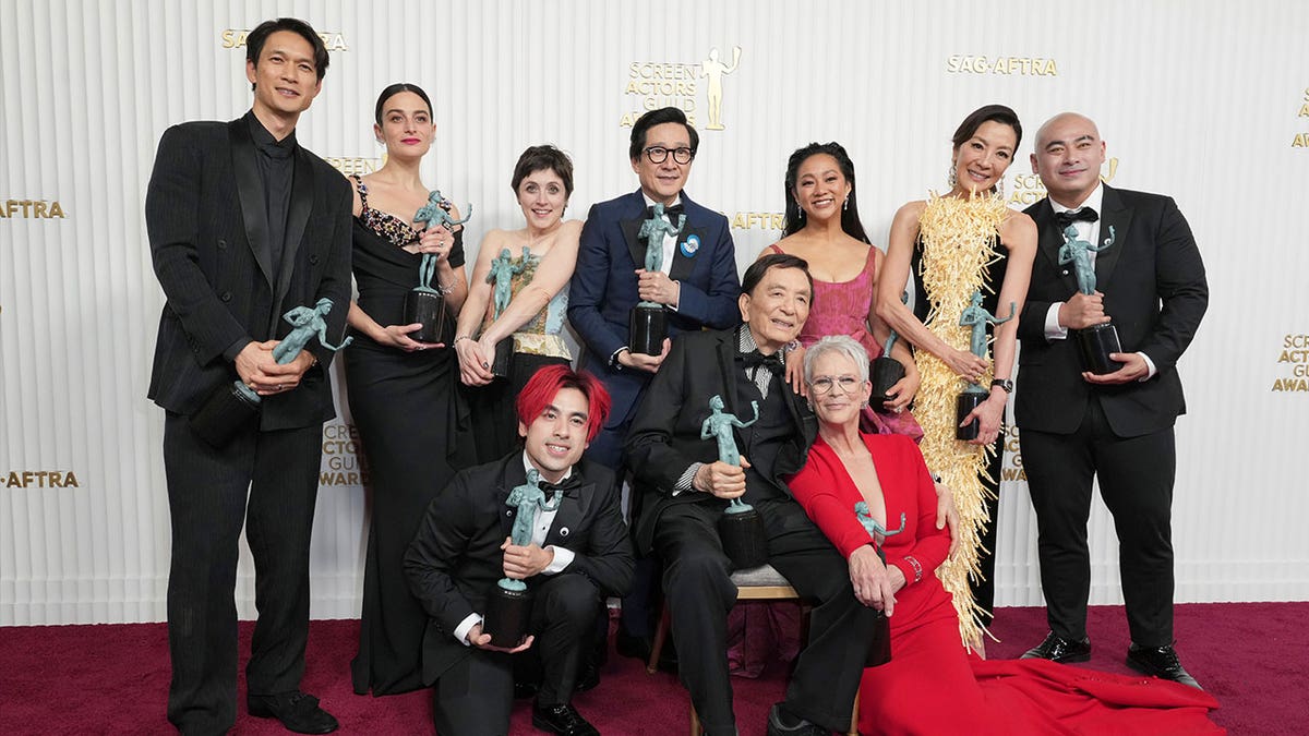 Harry Shum Jr., from back left, Jenny Slate, Tallie Medel, Ke Huy Quan, Stephanie Hsu, Michelle Yeoh, Brian Le, Andy Le, from front left, James Hong, and Jamie Lee Curtis pose with the award for "Everything Everywhere All at Once," at the 29th annual Screen Actors Guild Awards on Feb. 26, 2023.