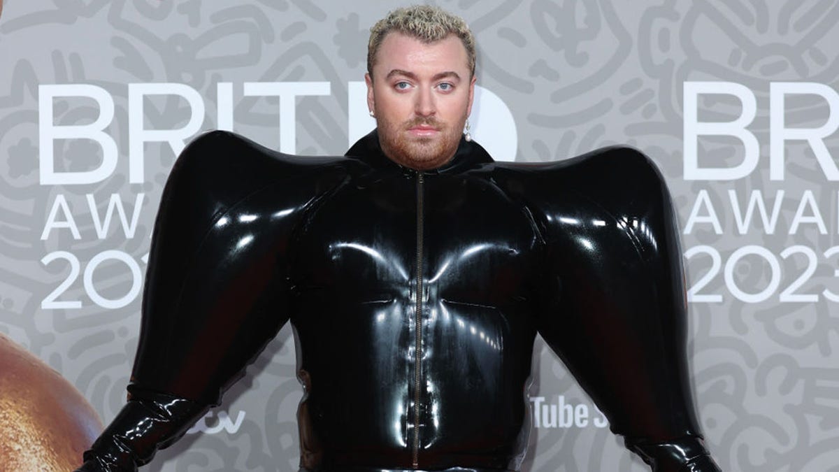 Sam Smith makes a bold fashion statement in a inflatable black latex  jumpsuit at the BRIT Awards