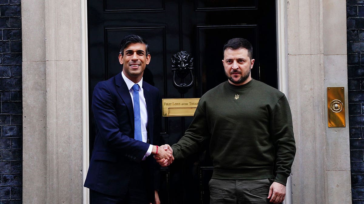 Sunak and Zelenskyy shake hands in front of black door at Downing Street
