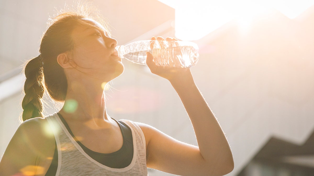 Woman drinking water after running