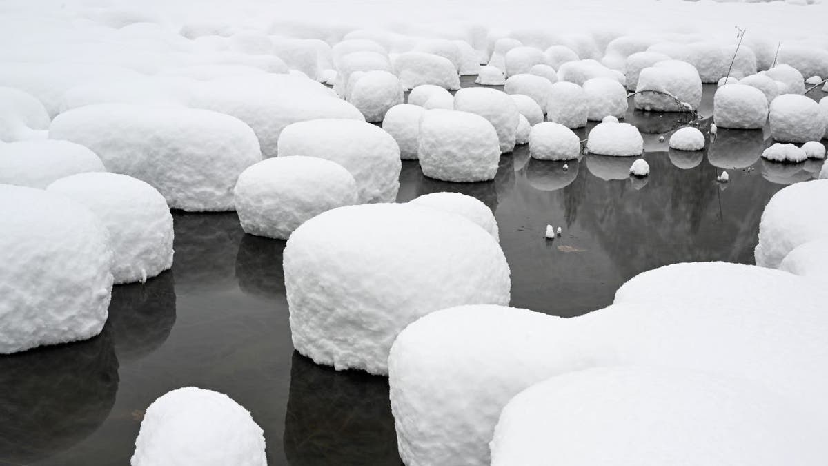 Snow blankets rocks on river at Yosemite