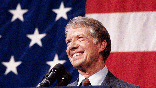 (Original Caption) 3/24/1979-Elk City, Okla.: Closeup of President Jimmy Carter, addressing a town meeting. American flag in background.