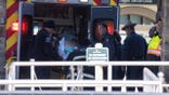 A person is lifted into an ambulance by emergency responders.