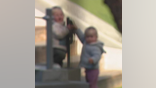 Two toddlers standing next to each other. Photo blurred for privacy
