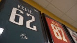 Framed Kelce brothers football Jerseys hang on the wall at Cleveland Heights High School