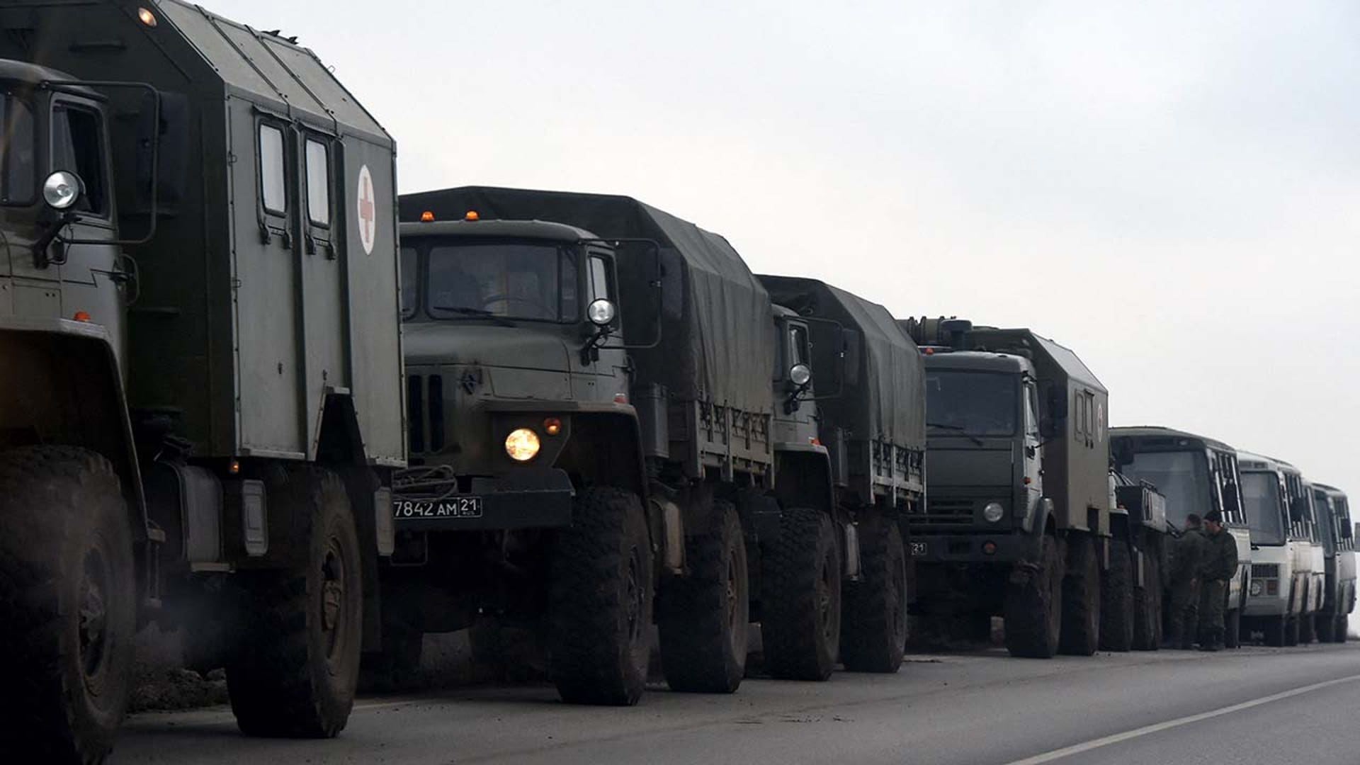 Russian military trucks and buses are seen on the side of a road in Russia's southern Rostov region, which borders the self-proclaimed Donetsk People's Republic, on February 23, 2022. (Photo by STRINGER / AFP) (Photo by STRINGER/AFP via Getty Images)