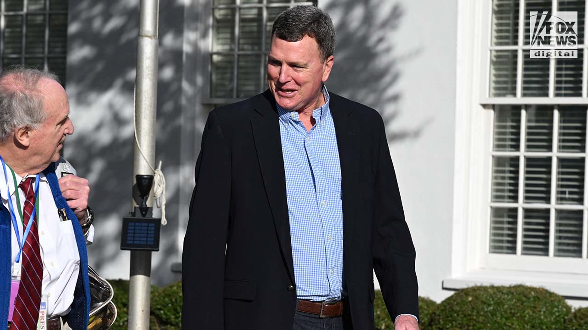 A man wearing a suit enters a courthouse.