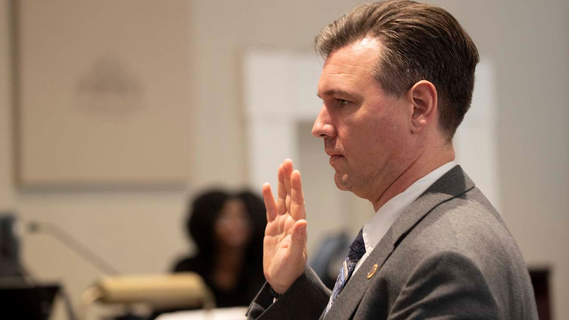 A man takes an oath inside a courtroom.