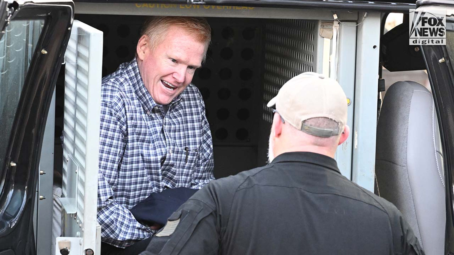 A man is escorted into a courthouse by police.