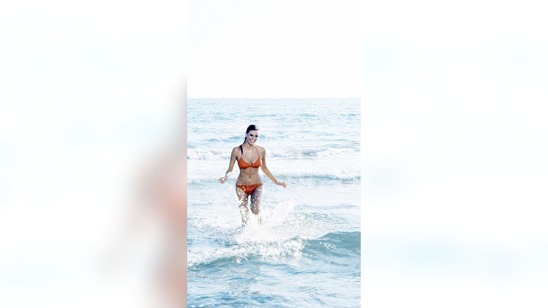 Welch stands in water at the beach.