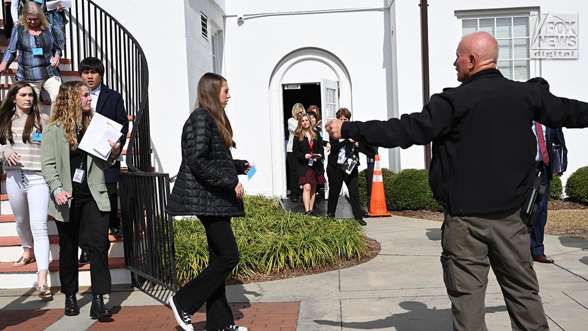 People walk out of the courthouse down the stairs and out of the doors