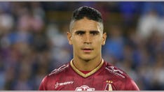 Fan punches Colombian soccer star on field; player's retaliation leads to red card