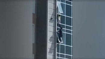 Good Samaritan in Kazakhstan climbs out window to save child dangling from building