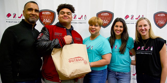 From left to right, Jon Seaton Sr., Elon University football player Jon Seaton, breast cancer survivor Carole Seaton, Fighting Pretty founder Kara Frazier and Fighting Pretty director of outreach Corrine Christian at the Feb. 2, 2023, event in Elon, North Carolina. Football player Seaton called it "one of the proudest moments of my life so far."